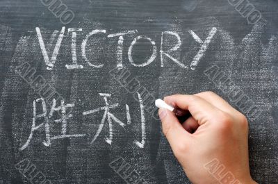 Victory - word written on a blackboard with a Chinese translation