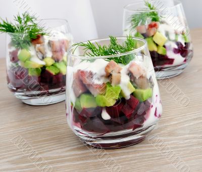 Appetizer in a glass of beet and herring with avocado