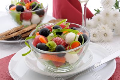 Salad of lettuce, cherry tomatoes, olives and mozzarella with pe