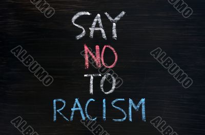 Say no to racism written on a smudged blackboard background