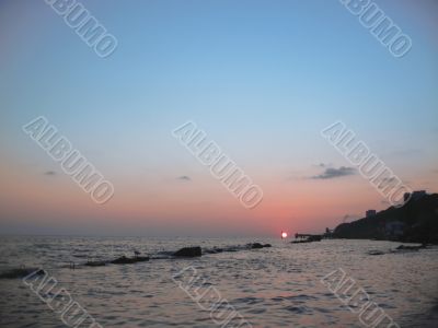 Round sun falling down over the Black sea