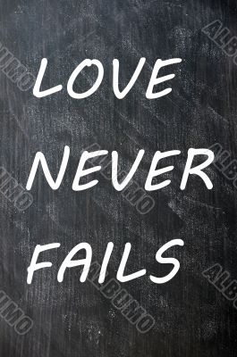 Love Never Fails written on a smudged chalkboard