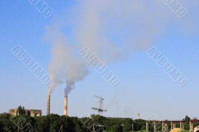 Smoke stacks of cement factory. Summertime landscape