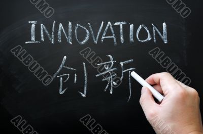 Innovation - word written with white chalk in both English and Chinese