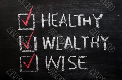 Being healthy, wealthy and wise written with chalk on a blackboard