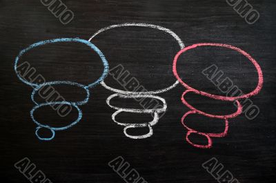 Blank speech bubbles drawn in chalk on a blackboard 