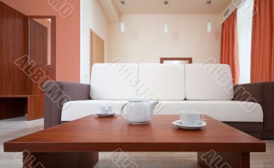 Teapot and cups on the background of the sofa