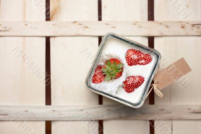 Strawberry falling into a container of milk