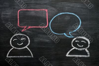 Blank speech bubbles with cartoon figures drawn on a blackboard background