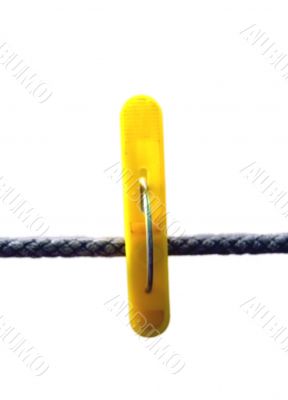 Yellow clothes peg and string on the white background isolated