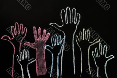 Happy volunteering hands on a blackboard background