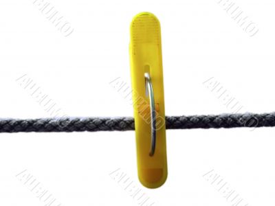 Yellow clothes peg and string on the white background isolated