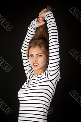 Beautiful girl in a striped dress pulls his hair
