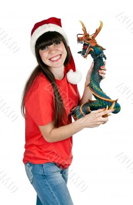 Girl in Santa hat with a decorative wooden dragon