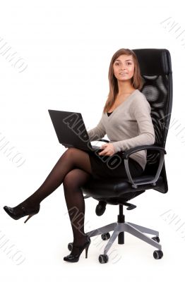 Young business lady in a chair with a laptop 