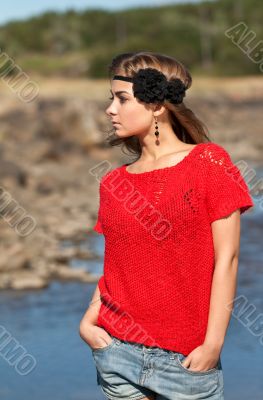 Beautiful girl in a red sweater and denim shorts