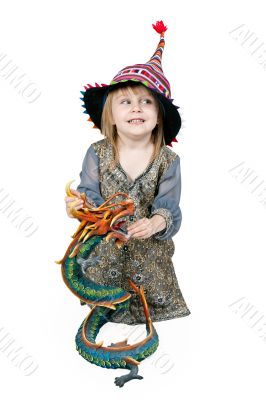 Little girl sitting on the floor with a decorative dragon 