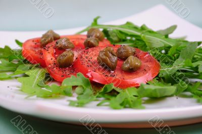 Salad with fresh tomatoes, capers and arugula