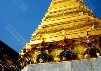 Statuettes Holding Up Gold Monument