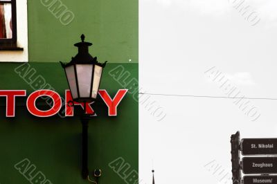 Nostalgic lamp in front of a green house facade