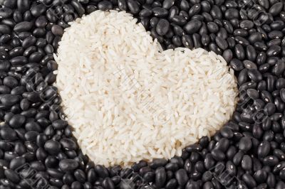 heart shape rice grains isolated on the dark beans