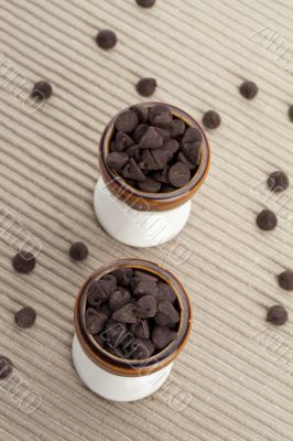 two cups of chocolate chips with strayed chips on the side