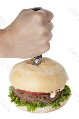 hand stabbing a hamburger
