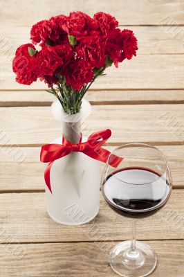 close up image of red flower and wine decorated on table