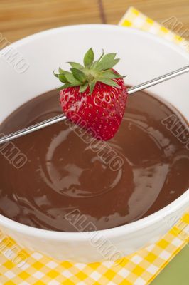 strawberry on stick over melted chocolate