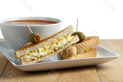 breakfast sandwich with egg and tomato soup on a bowl