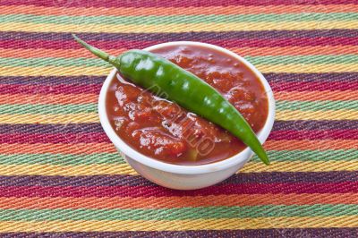 spicy salsa dip in bowl with green chili pepper