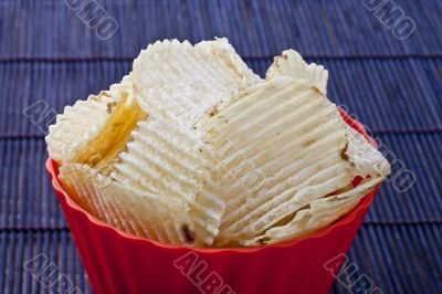fried potato chips in red plastic bowl