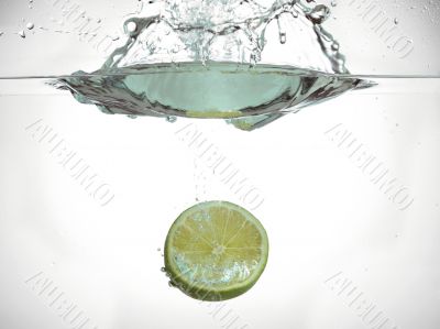 half of lime fruit splashing into the waterf