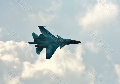 Jet in flight  on the background of white clouds