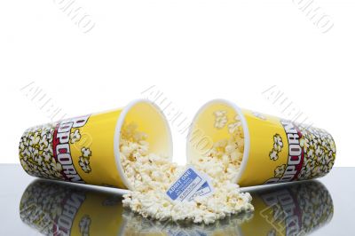 scattered popcorn from bucket with movie ticket