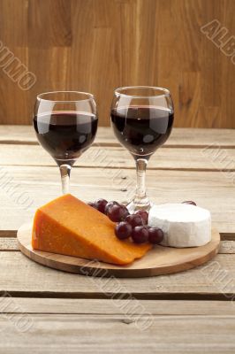 vertical image of cheese grapes and wineglass