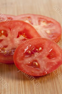 slices of fresh tomatoes on the wooden table slices of fresh tomatoes on the wooden table