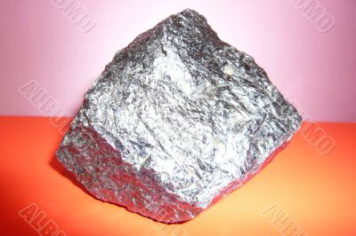 Gray shiny stone on a pink-red background.