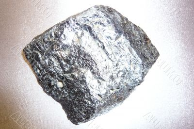 Silvery shiny stone on gray background