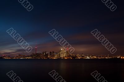 view of a illuminated city and sea at night  toronto ontario canada