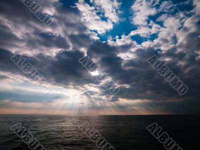 image of ocean and sun beams through clouds