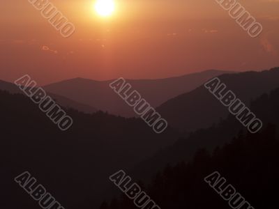 silhouette of mountains and sun