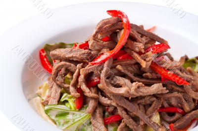 Salad of meat with red pepper on white plate