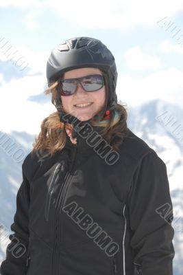 Young woman in ski clothes - mountains in the background