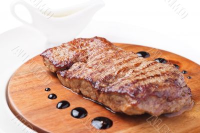a piece of grilled meat on a wooden board 