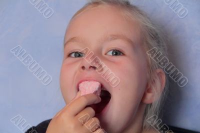 Beautiful small girl eating sweetmeat