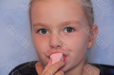 Beautiful small girl eating sweetmeat