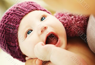 Beautiful newborn baby in a knit hat with beautiful blue eyes