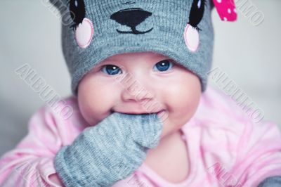 cute newborn baby girl in a funny hat and mittens cute newborn baby girl in a funny hat and mittens