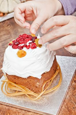 Hands decorating christmas cake